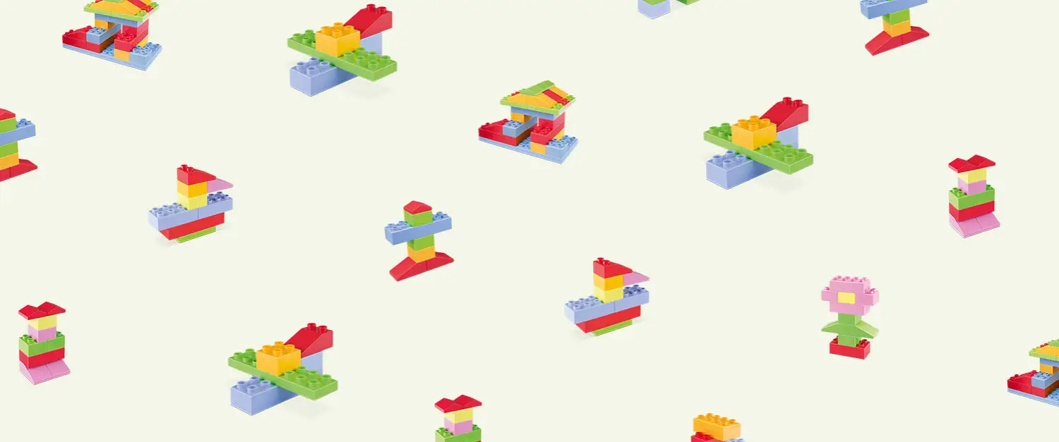Colourful eco toy bricks arranged on a pale background