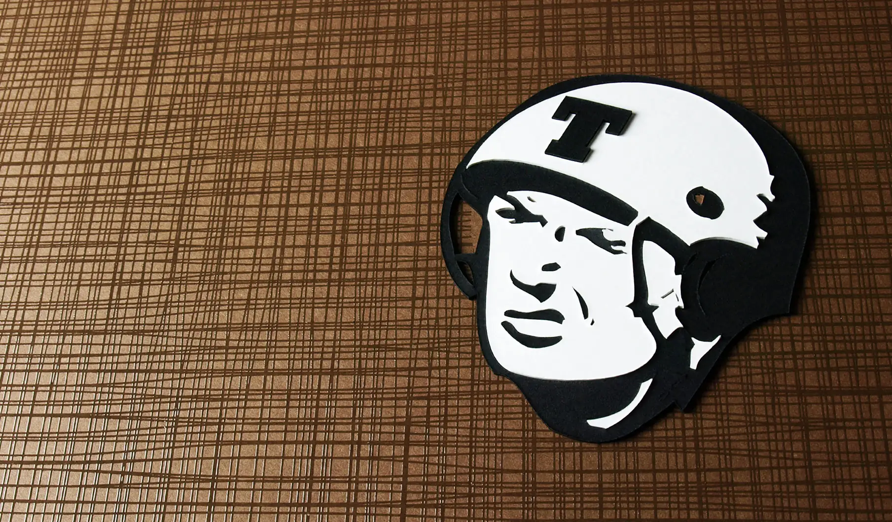The Trusty Boxes soldier logo cut from paper on a textured brown background